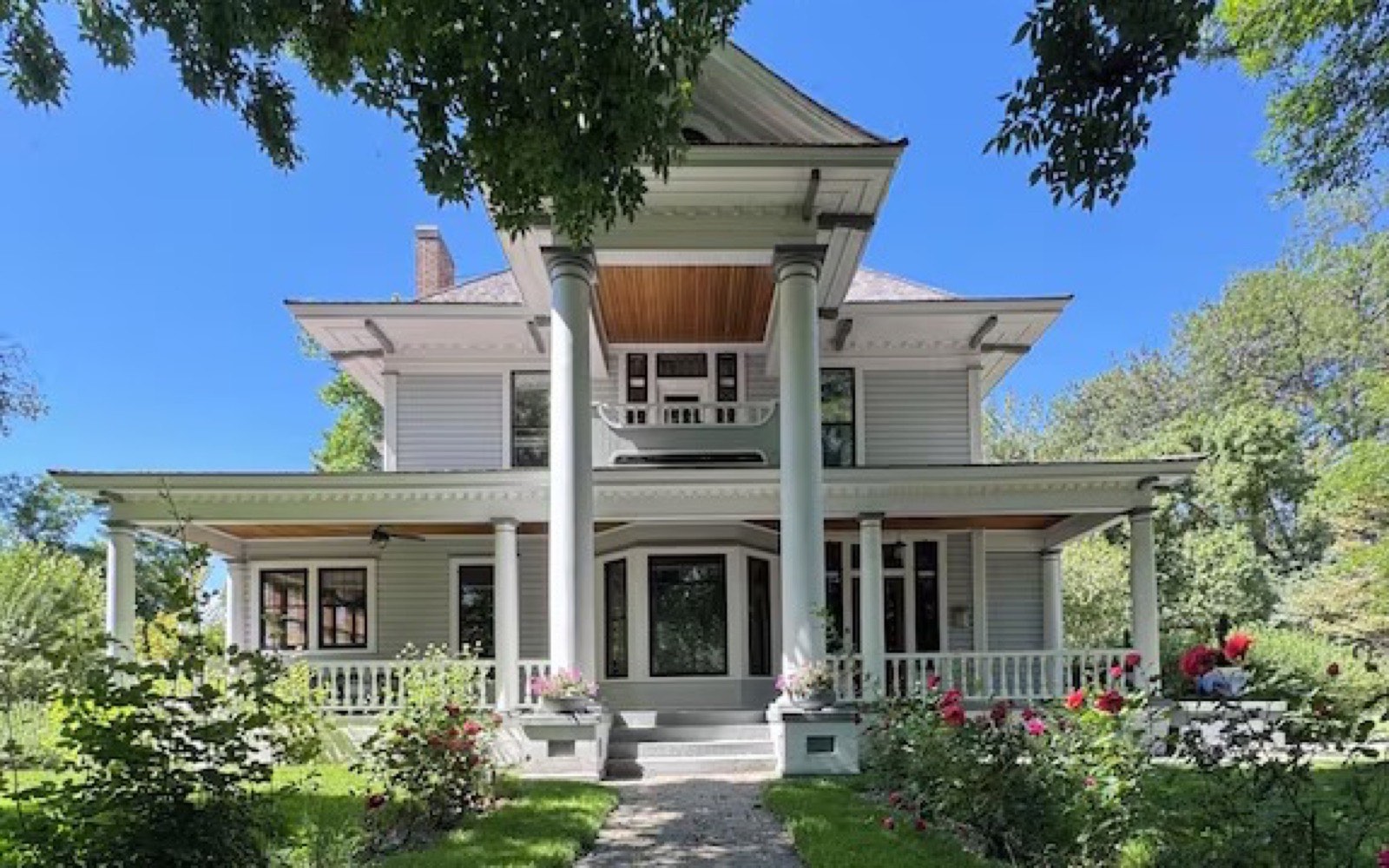 The Rosedale House, a historic home with a wraparound porch and a rose-lined front garden.